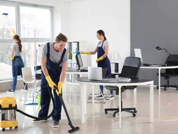 Team of janitors cleaning office